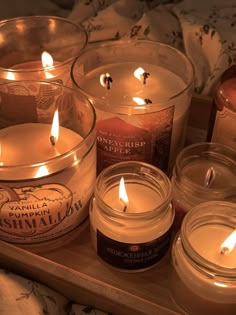 several candles are sitting on a wooden tray