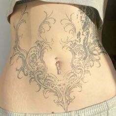 a woman's stomach with tattoos on it