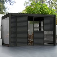 a small black shed sitting on top of a cement floor