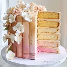 there is a cake with flowers on the top and two books in front of it