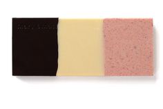 three bars of soap sitting on top of each other in different colors and shapes,