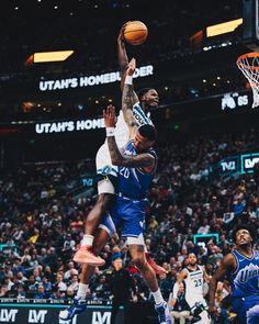 the basketball player is going to dunk the ball in front of the other player