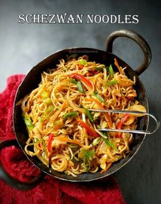 a pan filled with noodles and vegetables on top of a red towel