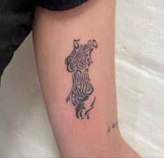 a black and white photo of a woman's arm with a tattoo on it