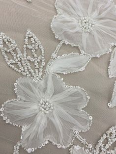 white flowers and pearls are on the fabric