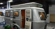 an rv parked in a garage with its doors open and the door opened to show what's inside