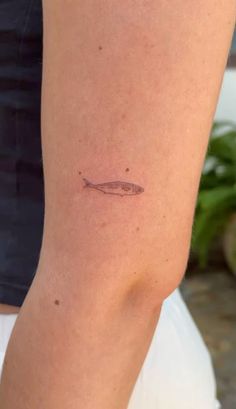 a person with a small tattoo on their arm that has a fish on it's side