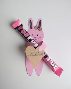 a pink bunny holding a heart shaped candy bar