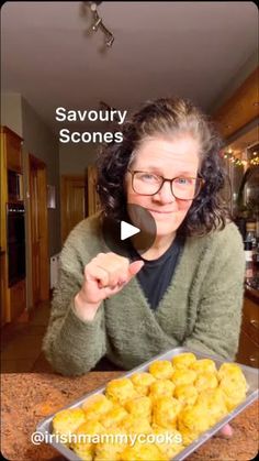 a woman holding a spoon over a pan filled with tater tots on top of a kitchen counter