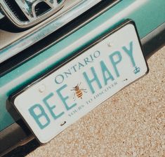 a license plate that says ontario bee happy on the side of a blue and white car