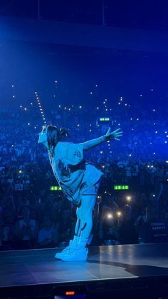 a person standing on top of a stage in front of a crowd