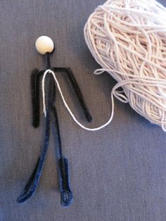 a ball of yarn and two crochet hooks laying on a blue table cloth