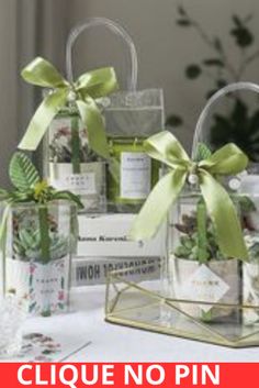 four clear bags with green bows on them sitting on top of a white table cloth