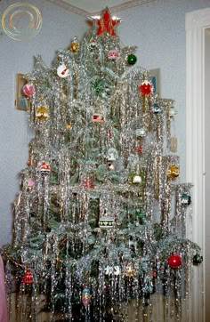 a silver christmas tree with ornaments on it