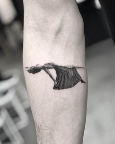 a black and white photo of a woman's leg with a tattoo on it