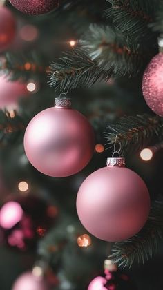 pink ornaments hanging from the top of a christmas tree