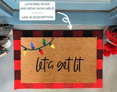 a door mat with the words let's got it written on it next to christmas decorations