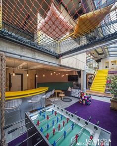 an indoor game room with foo pong tables and colorful rugs on the floor