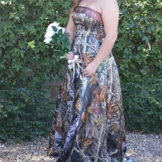 a woman in a long dress holding a flower