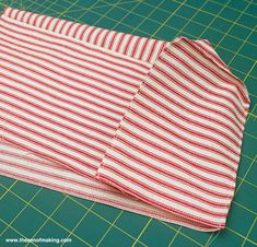 red and white striped fabric sitting on top of a cutting board