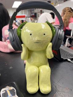 a yellow teddy bear with headphones sitting on a table