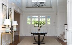 a living room filled with furniture and a large vase on top of a coffee table