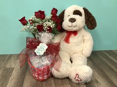 a white stuffed dog sitting next to a bouquet of roses and a valentine's day gift