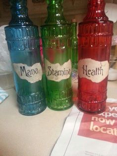 three colorful bottles sitting on top of a counter