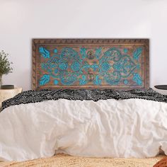 the bed is made up with white linens and blue flowers on it, along with a wooden headboard