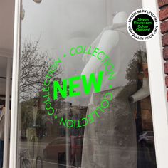 there is a window with the words new in green on it and people standing outside