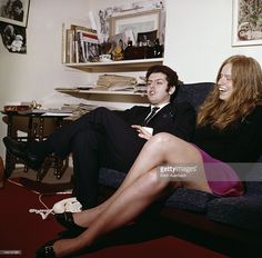 a man and woman sitting on a couch laughing