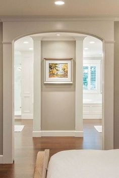 an empty bedroom with white walls and wood flooring is seen in this image from the doorway