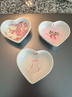 three heart shaped dishes sitting on top of a counter