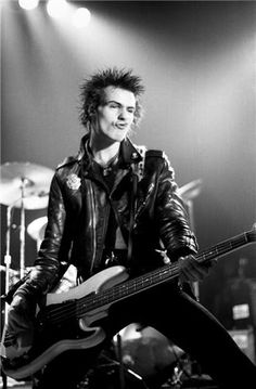 a man with punk hair playing guitar on stage