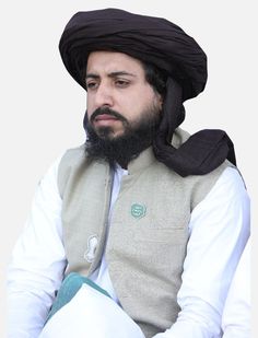 a man wearing a black turban sitting down