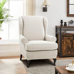 a living room with a white chair and coffee table in front of a large window