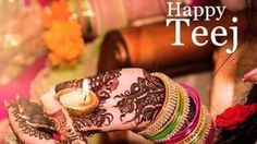 a woman with henna on her hands holding a lit candle in front of flowers