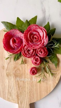 some red flowers are sitting on a cutting board