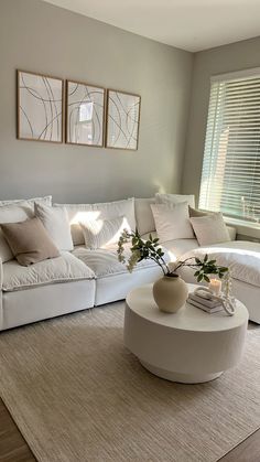 a living room filled with white furniture and pillows