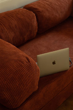 an apple laptop sitting on top of a couch