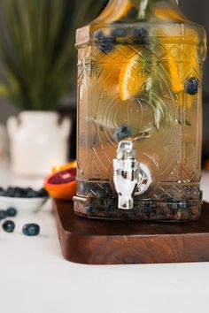 a glass jug filled with lemons and blueberries