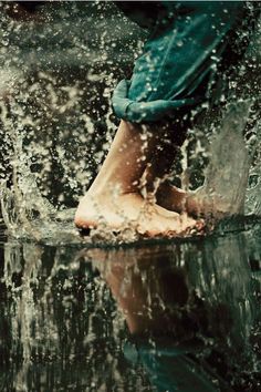 a person standing in the water with their feet up