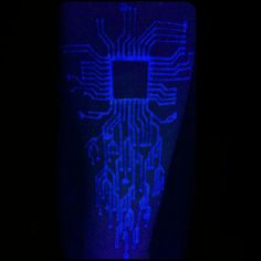 an electronic circuit board lit up in the dark with blue light coming from it's side