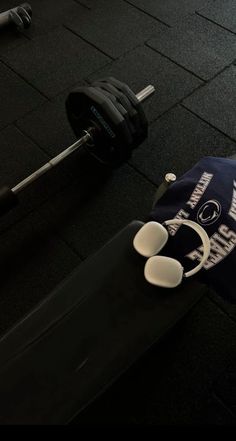 a pair of shoes sitting on the ground next to a barbell and weight rack