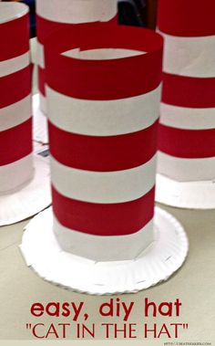 four red and white striped paper cups sitting on top of a table with the words, easy diy hat cat in the hat