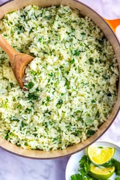 a pot filled with rice and garnished with cilantro on the side