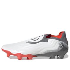 a white and grey soccer shoe with red accents