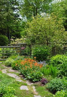 a garden with lots of plants and flowers in it's center, surrounded by trees