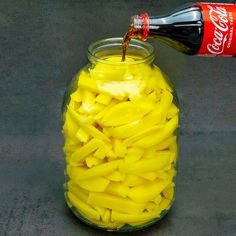 a glass jar filled with sliced yellow bananas next to a coca - cola drink bottle