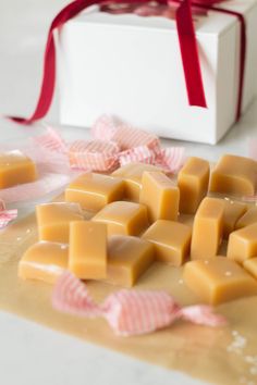 several pieces of soap sitting on top of a table next to a box with a red ribbon